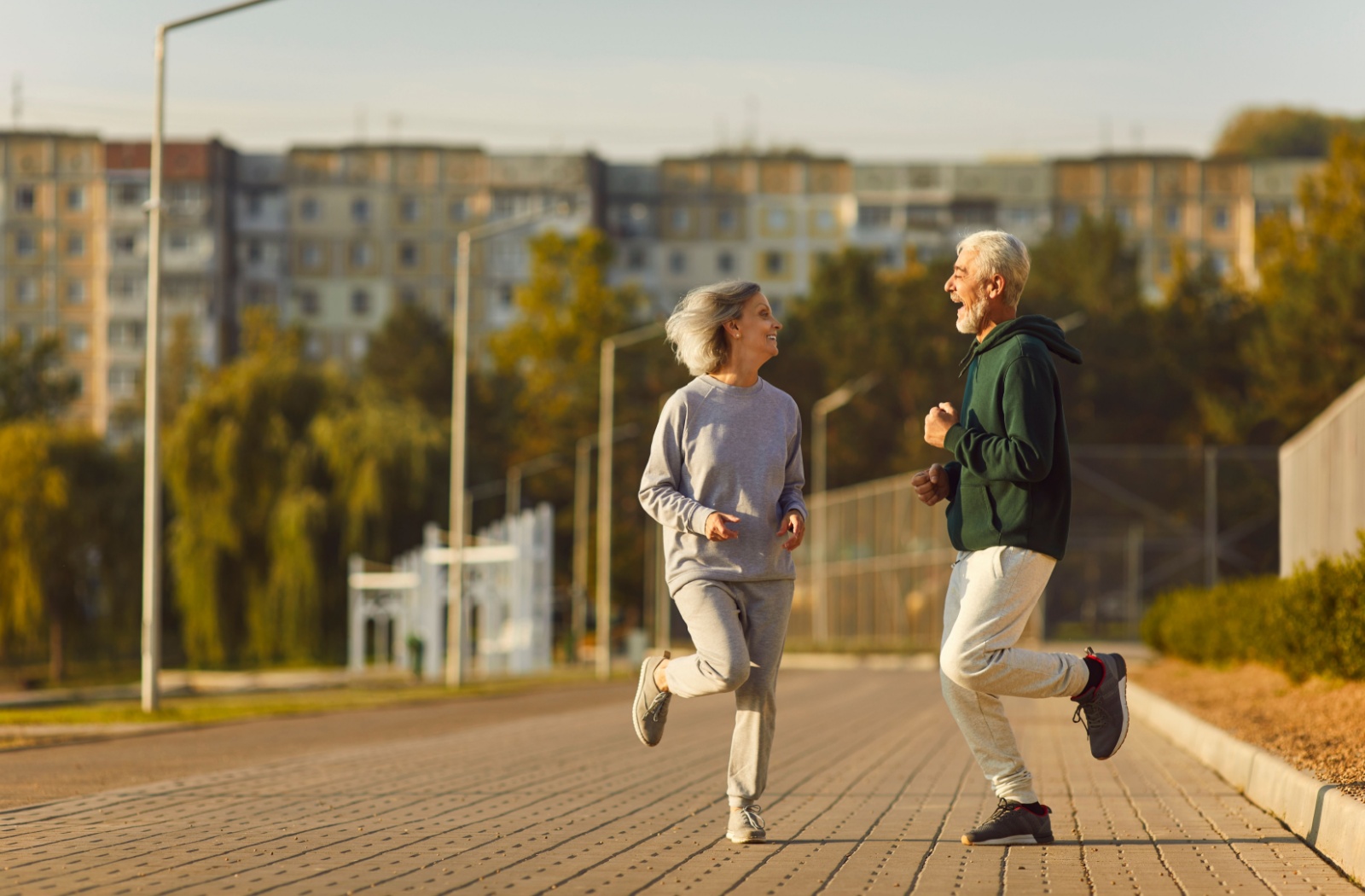 Two seniors enjoying a run together on a sunny day.