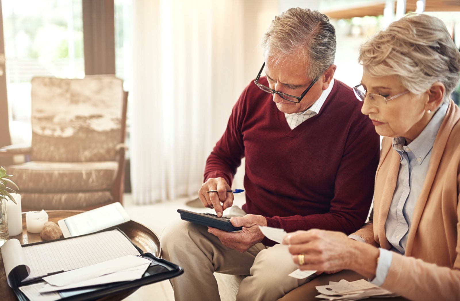 A senior couple go through financial documents to assess their financial situation for a move to independent living