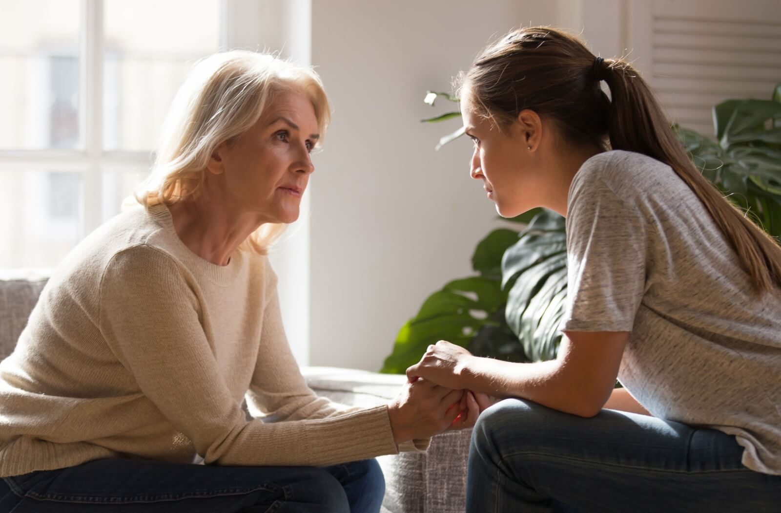An adult talks gently to their senior parent about moving into assisted living.