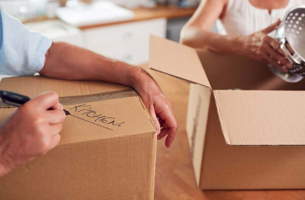 Close-up of senior couple downsizing, packing things to bring into the new home.