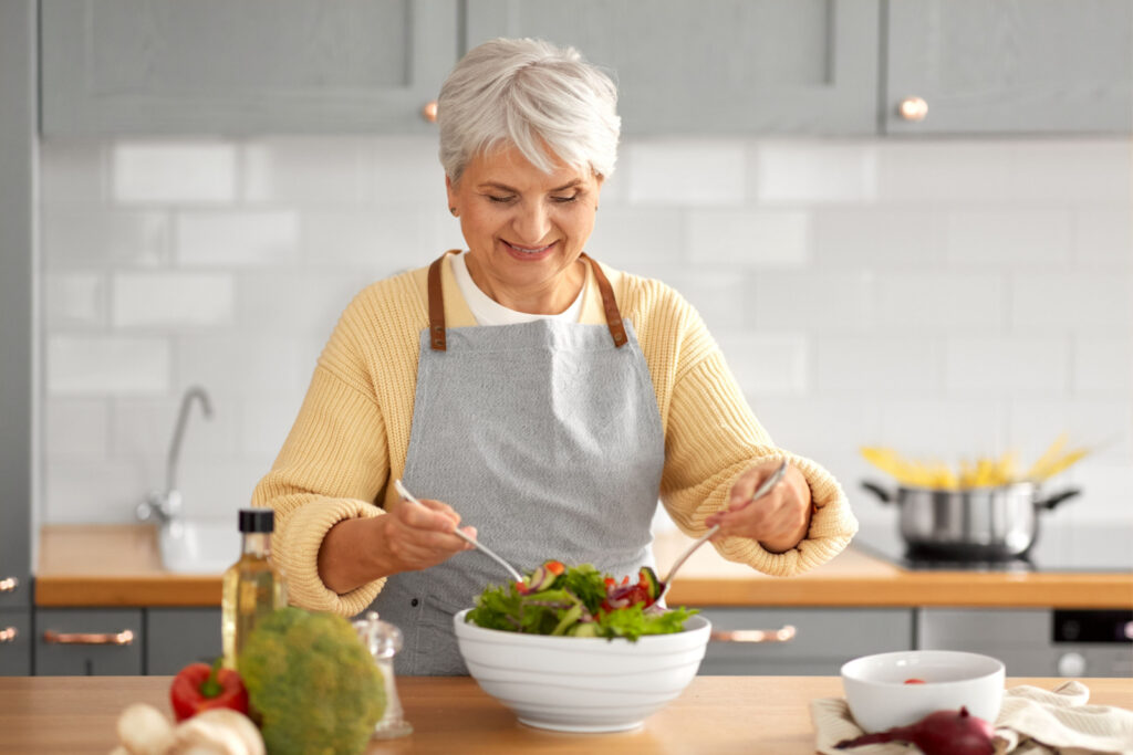 Senior woman is preparing a healthy meal to stay physically active.