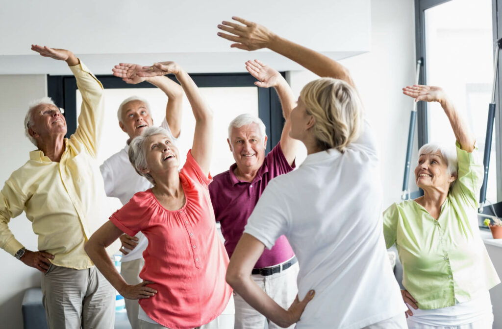 A group of seniors exercising together under the supervision of a trained staff.