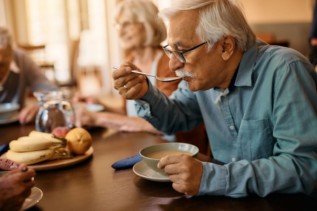 Older man enjoying a meal in an independent living community.