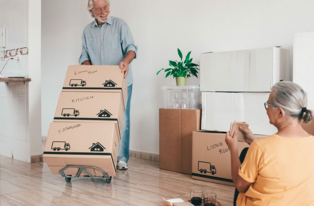 an older man and older woman are moving boxes to their assisted living community.