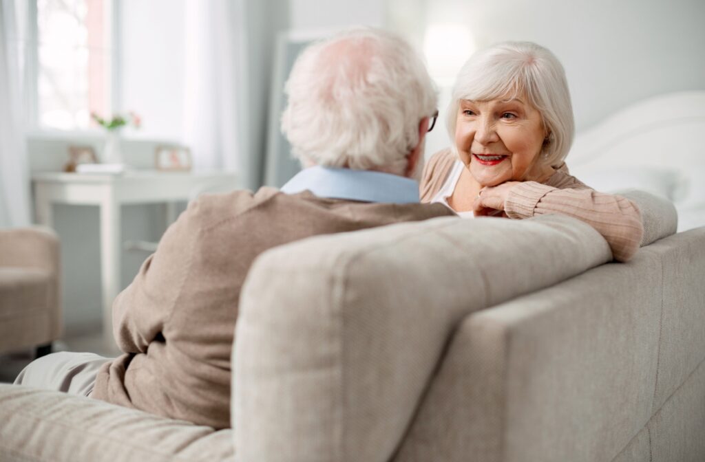 An older couple in independent living sitting on the couch and talking.