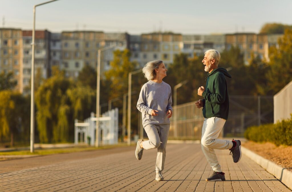 Two seniors enjoying a run together on a sunny day.